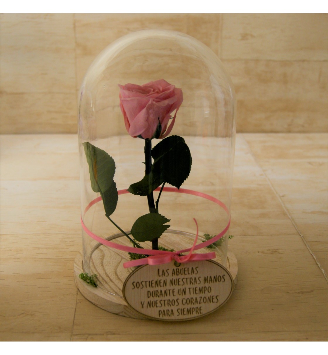 Cúpula de cristal y base de madera con rosa eterna rosa en su interior
