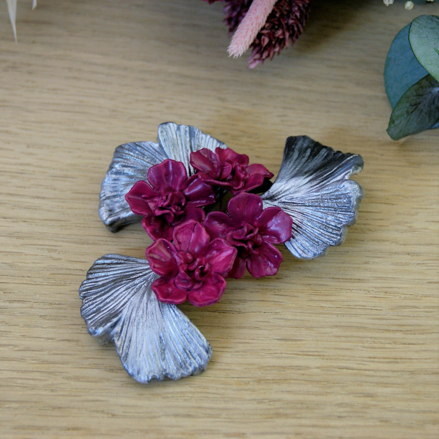 pianista nudo Desconexión Tocado de porcelana fría, con flores fucsia y hojas plateadas.